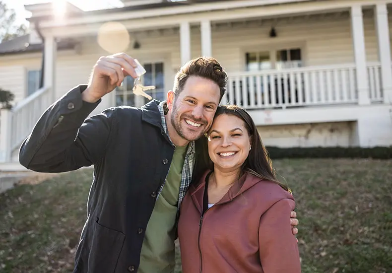 smiling couple in front of newhome